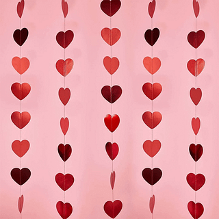 Rode hartjes met metallic effect hangen voor een roze achtergrond