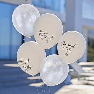 Set ballonnen in het nude en zilver met teksten voor een vrijgezellenfeest zweven bij een zwembad