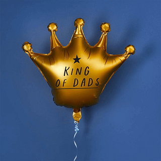 Gouden folieballon in de vorm van een kroon met de tekst king of dads zweeft voor een marineblauwe muur
