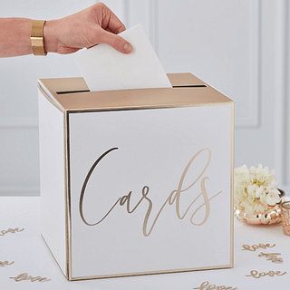 witte met gouden doos met hierop de tekst cards staat op een witte tafel naast rozen en gouden confetti