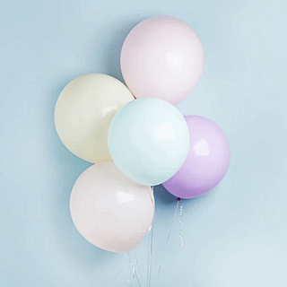 pastelkleurige reuzeballonnen voor een blauwe muur
