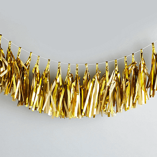 gouden tassel slinger hangt voor een grijze muur