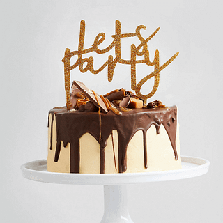 Chocolade en karameltaart is versierd met een gouden glitter topper met de tekst lets party