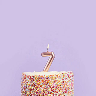 rose gouden taart kaars cijfer in een regenboog taart met spikkels voor een paarse muur