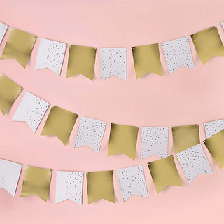 gouden en witte vlaggetjes in de vorm van vaantjes hangen voor een roze muur