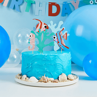 sateprikkers met tropische vissen, koraal en zeepaardjes zitten in een blauwe taart versierd met schelpen