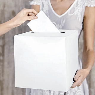 Witte kaartendoos word vastgehouden door een vrouw in een trouwjurk