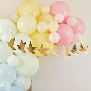 slnger met gouden duiven hangt voor een ballonnenboog met mintgroene, pastelblauwe, pastelgele en pastelroze ballonnen