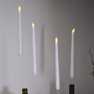 Zwevende, witte kaarsen met LED verlichting hangen boven bruine vaasjes en takken