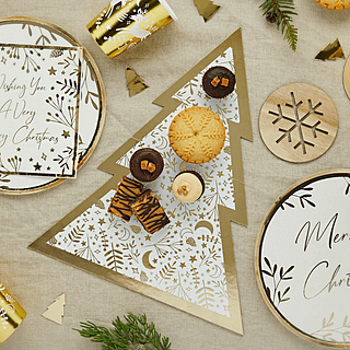 Hapjesplank in de vorm van een kerstboom in het wit en goud ligt op een jute tafelkleed en is gevuld met lekkere hapjes