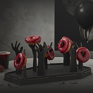 Donut standaard in de vorm van een grafkist met zombiehanden die rode donuts vasthouden