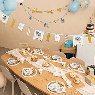 Versierde tafel voor een babyshower met safari thema met gouden en blauwe versiering