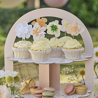 Cupcake toppers met papieren bloemen zitten in cupcakes op een cupcake standaard
