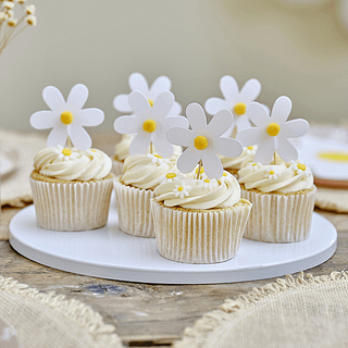 Sate prikkers zitten in cupcakes in de vorm van een madeliefje met een gele pom pom