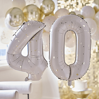 Cijferballonnen 40 in het nude met gouden spikkels hangt voor een ballonnenboog en gouden backdrop