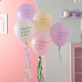 Pastel ballonnen met de tekst happy birthday en streamers eronder hangen voor een boog
