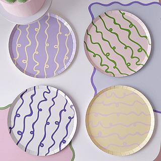 Pastel bordjes met swirls en krulletjes erop staan op een pastel tafel
