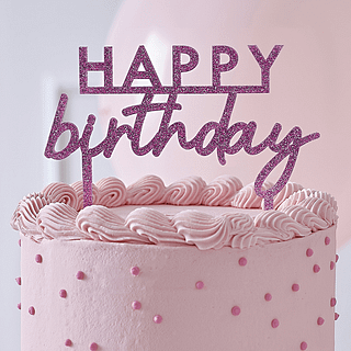 Roze glitter taart topper met de tekst happy birthday zit in een roze taart met donkerroze stippen