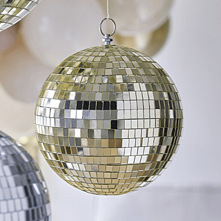 Gouden discobal hangt tussen zilveren discoballen en een beige ballonnenboog
