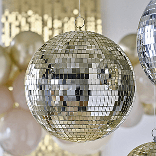 Gouden discobal hangt voor een beige ballonnenboog en gouden backdrop
