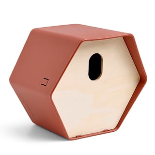 vogel huis met bruine kunststof buitenkant in de vorm van een hexagon met ovaal gat