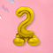 Folieballon cijfer 2 in de kleur goud op standaard op een roze achtergrond