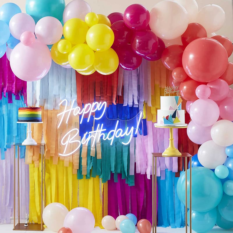 wand met kleurrijke streamers en multicolor ballonnenboog en happy birthday bord
