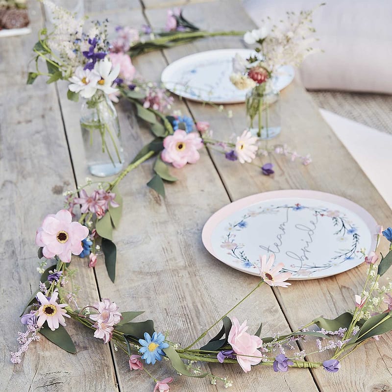 steigerhouten tafel met witte papieren bordjes met team bride en een kunst weidebloemen