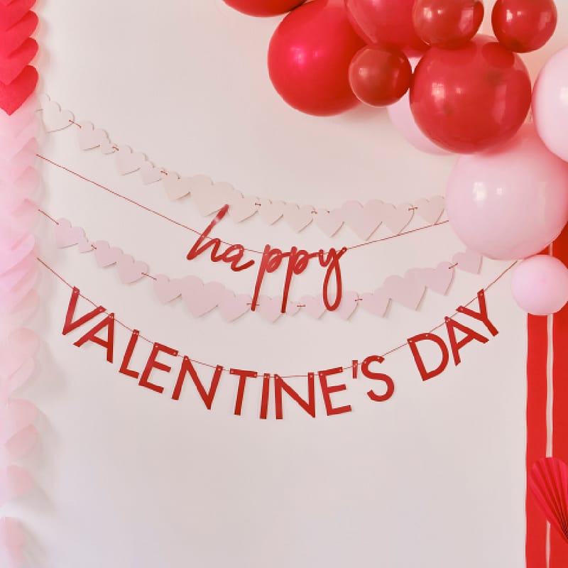 Slingers met roze hartjes en een rode tekst 'Happy Valentines Day' omringd door ballonnen
