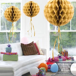Drie gouden honeycombs in een kamer met cadeaus en ballonnen