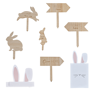Houten bordjes met pijlen en konijntjes erop die de weg wijzen in een Egg Hunt