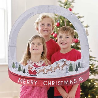 Drie kinderen met foto frame met merry christmas erop