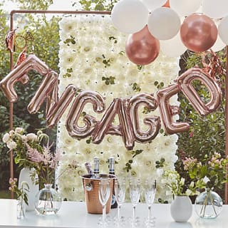 Versierde tafel met champagne en daarboven een folieballon met de tekst engaged