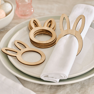 Mintgroen bord met houten servettenringen met konijnenoren en een witte servet