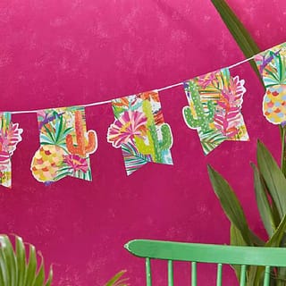 Vlaggetjes met tropisch design op een roze achtergrond met groene planten