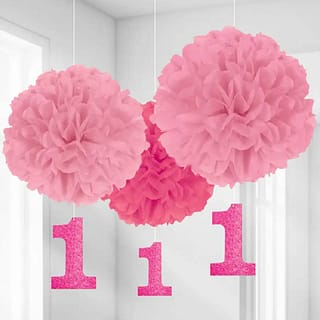Drie roze pom poms met daaraan roze kaartjes in de vorm van het cijfer 1