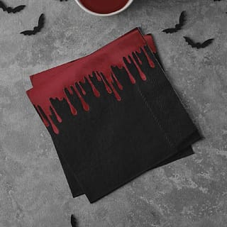 Stapeltje met zwarte servetten met lekkende bloedsporen erop en vleermuisconfetti