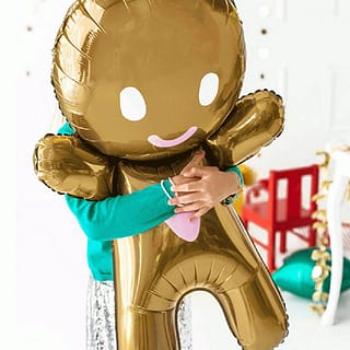 Kind knuffelt een taaitaaivormige folieballon