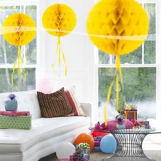 Drie gele honeycombs in kamer met cadeautjes en ballonnen