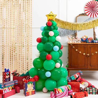 Versierde kamer met cadeaus slingers waaiers en een kerstboom van ballonnen