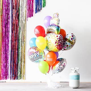 Witte heliumtank met een ballonboeket in verschillende kleuren