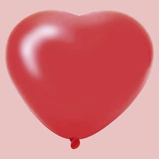 Rode hartvormige ballon op lichtroze achtergrond