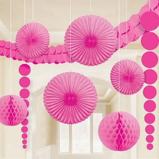 Roze waaiers honeycombs en slingers hangen in kamer