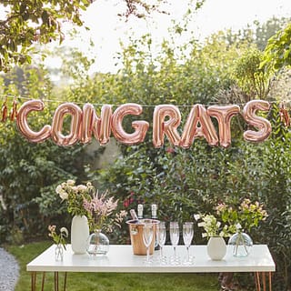 Folie ballon met tekst Congrats boven tafel met champagne