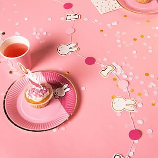 Tafel met nijntje slinger, nijntje bordje met cupcake erop en roze confetti
